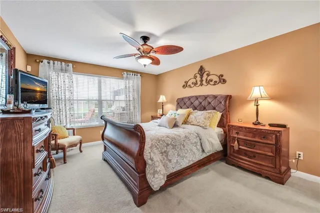 a spacious bedroom with a bed and a flat screen tv