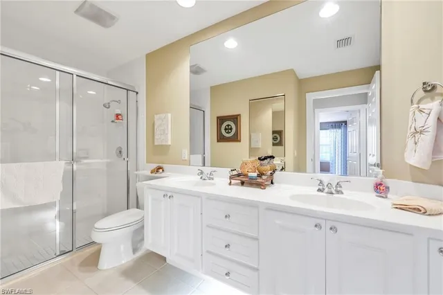 a bathroom with a double vanity sink toilet mirror and bathtub