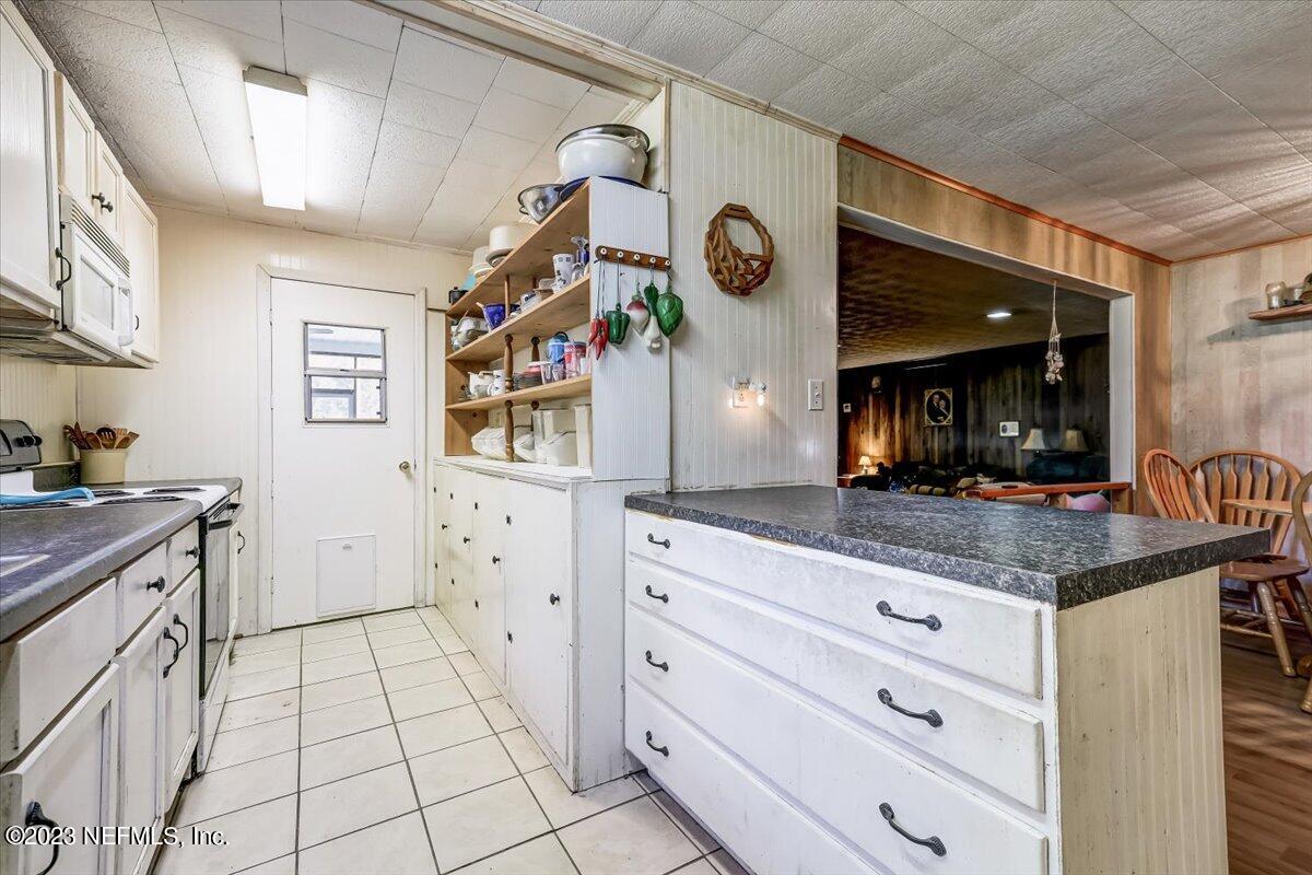86290 Weldon Road Yulee, FL 32097 - Photo 13 of 46 a kitchen with granite countertop white cabinets and stainless steel appliances