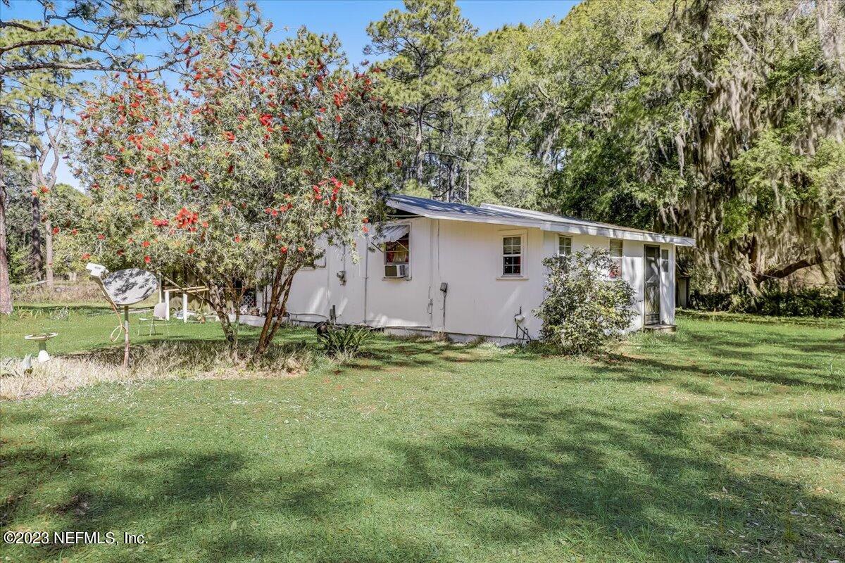 86290 Weldon Road Yulee, FL 32097 - Photo 4 of 46 a backyard of a house with plants and large tree
