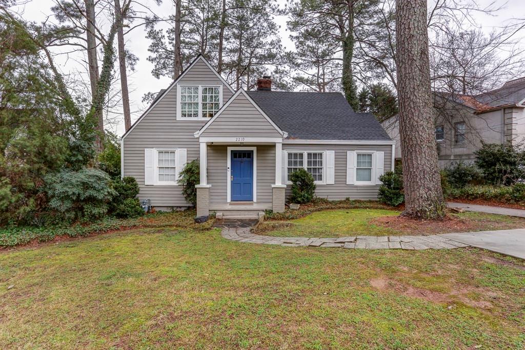 a front view of a house with a garden and trees