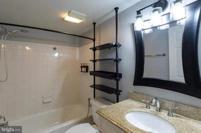 a bathroom with a granite countertop sink toilet and shower
