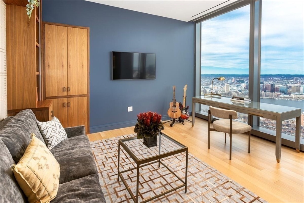 1 Dalton Street, Unit 5402 Boston, MA 02115 - Photo 11 of 17 a living room with furniture tv and a floor to ceiling window