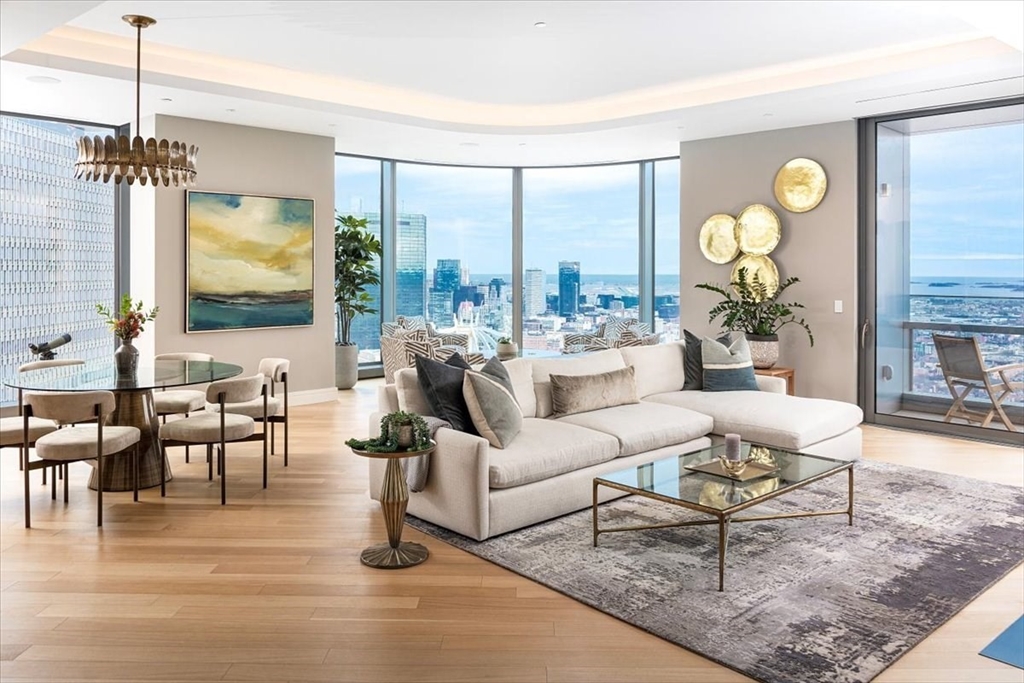 1 Dalton Street, Unit 5402 Boston, MA 02115 - Photo 3 of 17 a living room with couches a coffee table and a large mirror with wooden floor