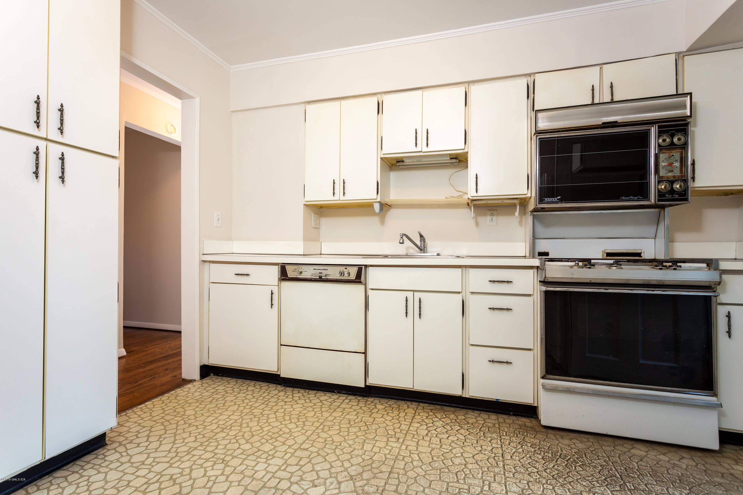 20 Silver Beech Road Riverside, CT 06878 - Photo 10 of 33 a kitchen with stainless steel appliances a stove a microwave and white cabinets