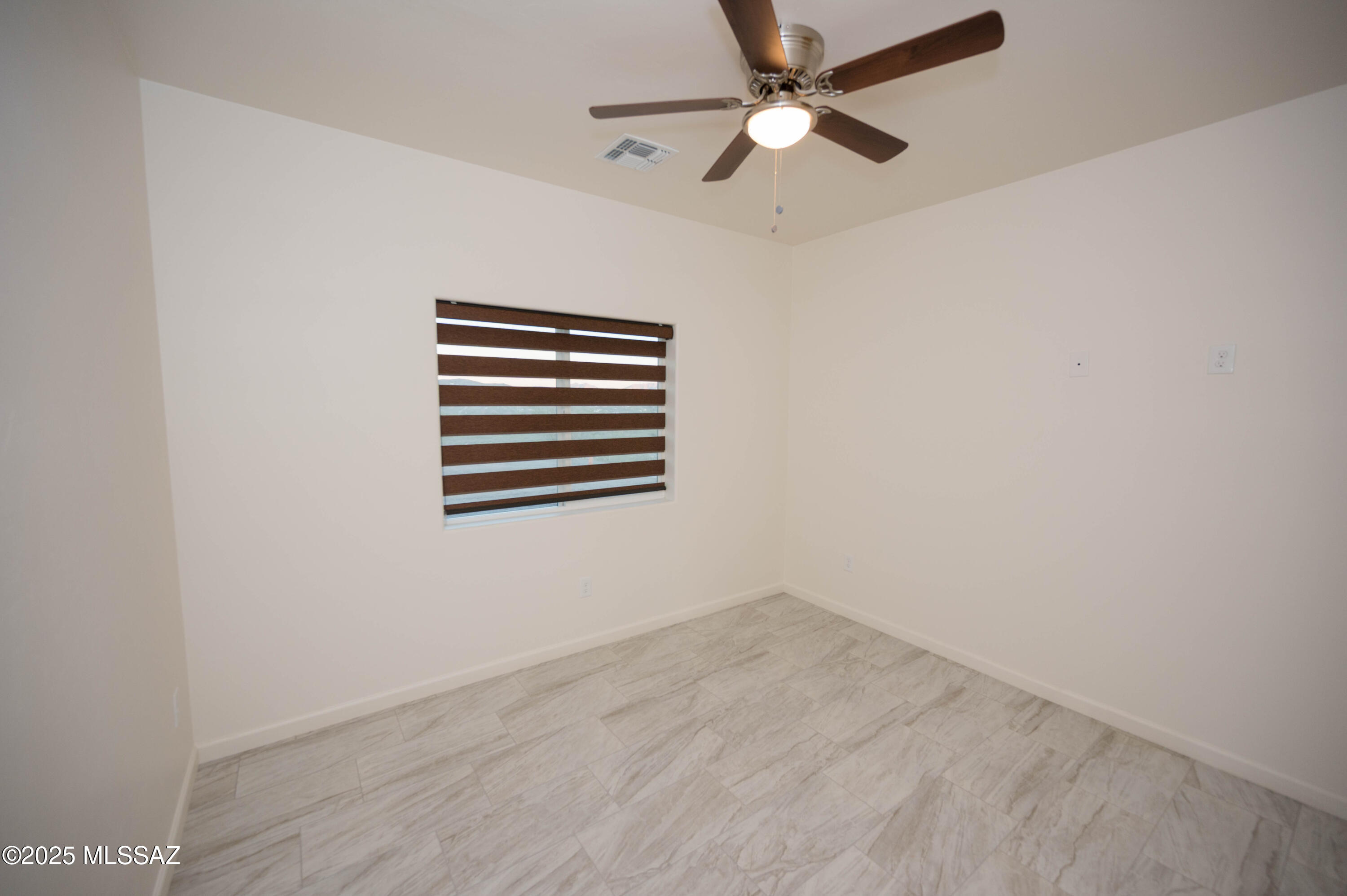 497 Calle Cipres Rio Rico, AZ 85648 - Photo 30 of 50 an empty room with a window and ceiling fan