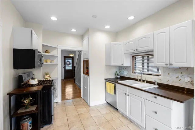 a kitchen with stainless steel appliances kitchen island granite countertop a sink cabinets and refrigerator