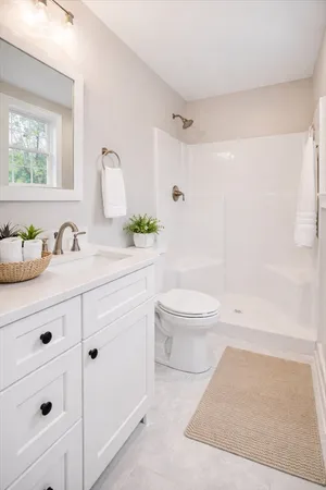 a bathroom with a sink a toilet and shower