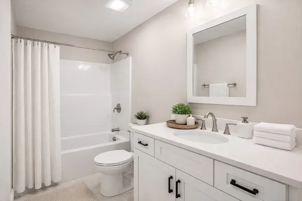 a bathroom with a sink a toilet and shower curtain