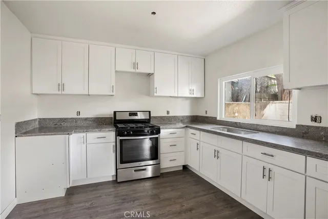 a view of an empty room with wooden floor and window