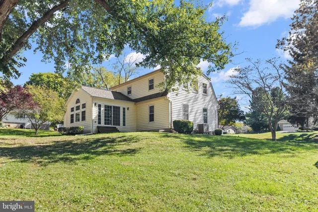 a view of a house with a big yard and large trees