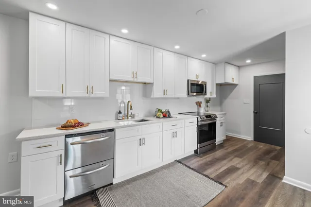 a kitchen with white cabinets and stainless steel appliances