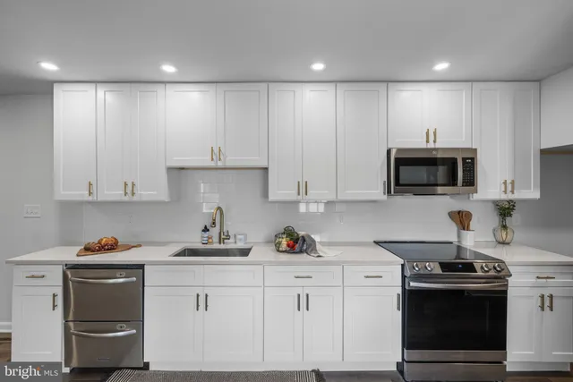 a kitchen with stainless steel appliances granite countertop a sink stove and cabinets