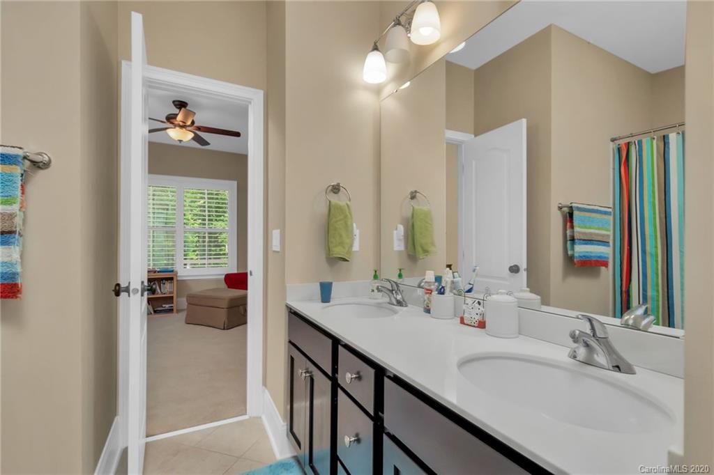 1401 Delaney Drive Weddington, NC 28104 - Photo 28 of 48 a en suite bathroom with a granite countertop sink a large mirror and a bathtub