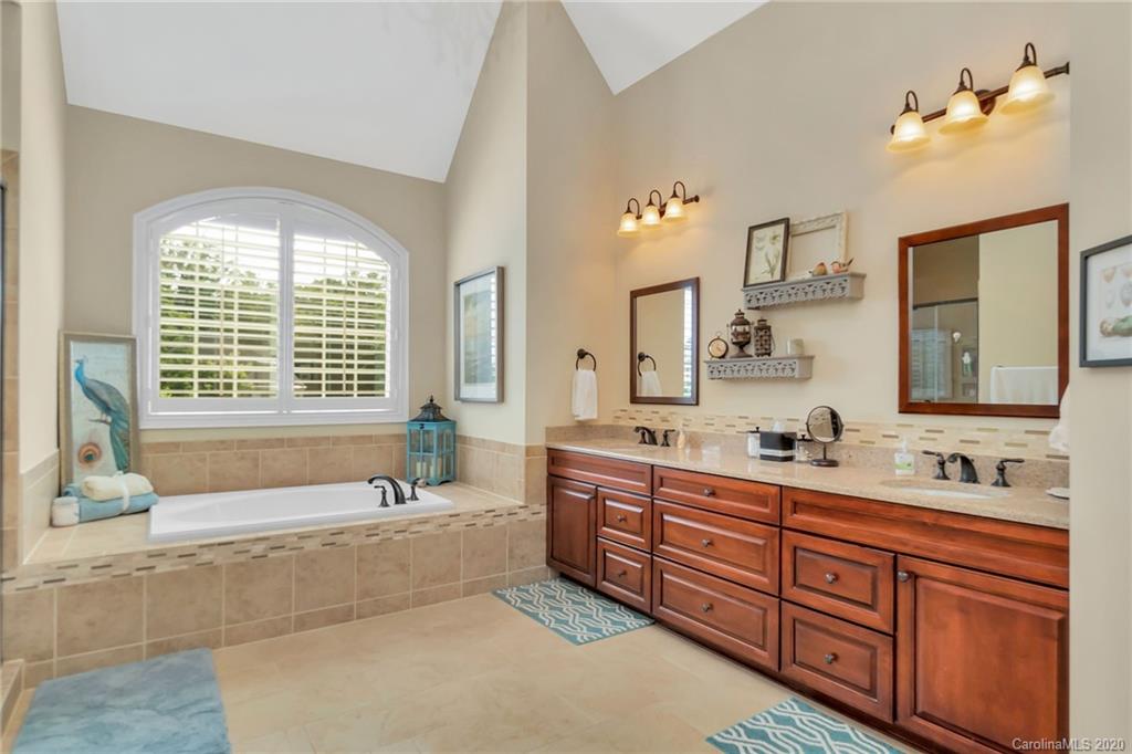 1401 Delaney Drive Weddington, NC 28104 - Photo 35 of 48 a spacious bathroom with double vanity a window a large mirror and a bathtub