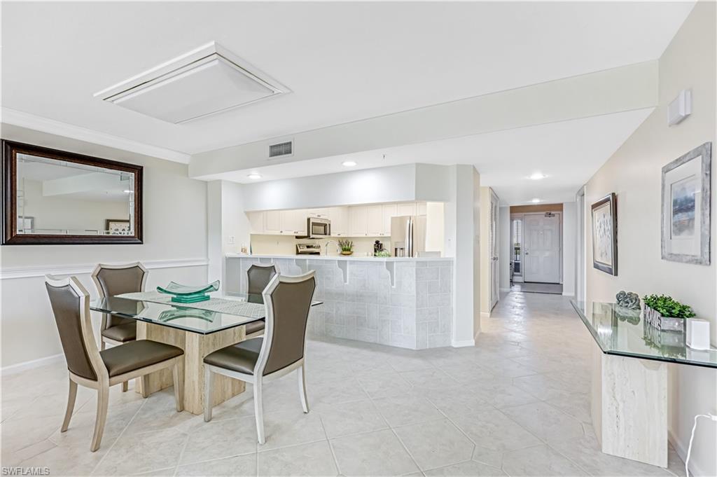 21 Bluebill Avenue, Unit B503 Naples, FL 34108 - Photo 20 of 40 a view of a dining room with furniture and wooden floor