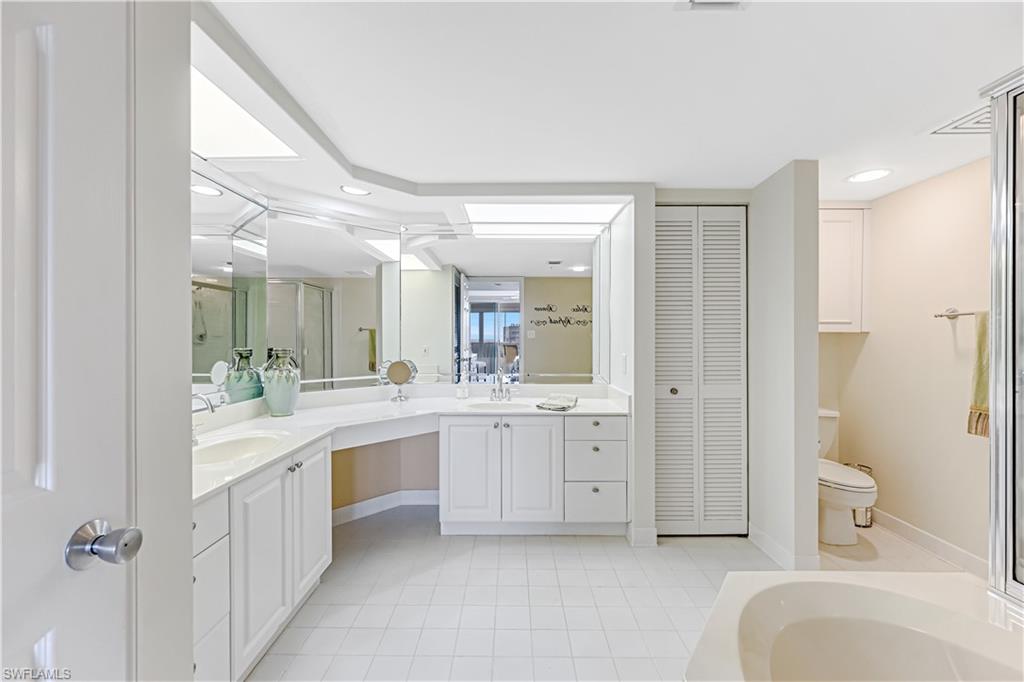 21 Bluebill Avenue, Unit B503 Naples, FL 34108 - Photo 23 of 40 a large bathroom with a granite countertop sink mirror and a bathtub