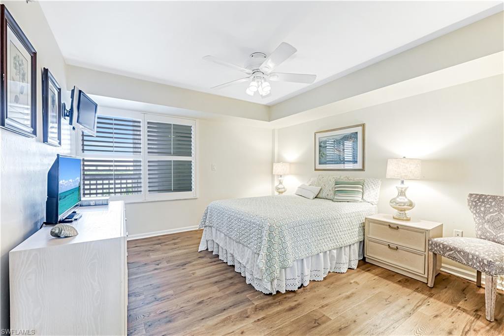 21 Bluebill Avenue, Unit B503 Naples, FL 34108 - Photo 25 of 40 a bedroom with a bed and a chandelier