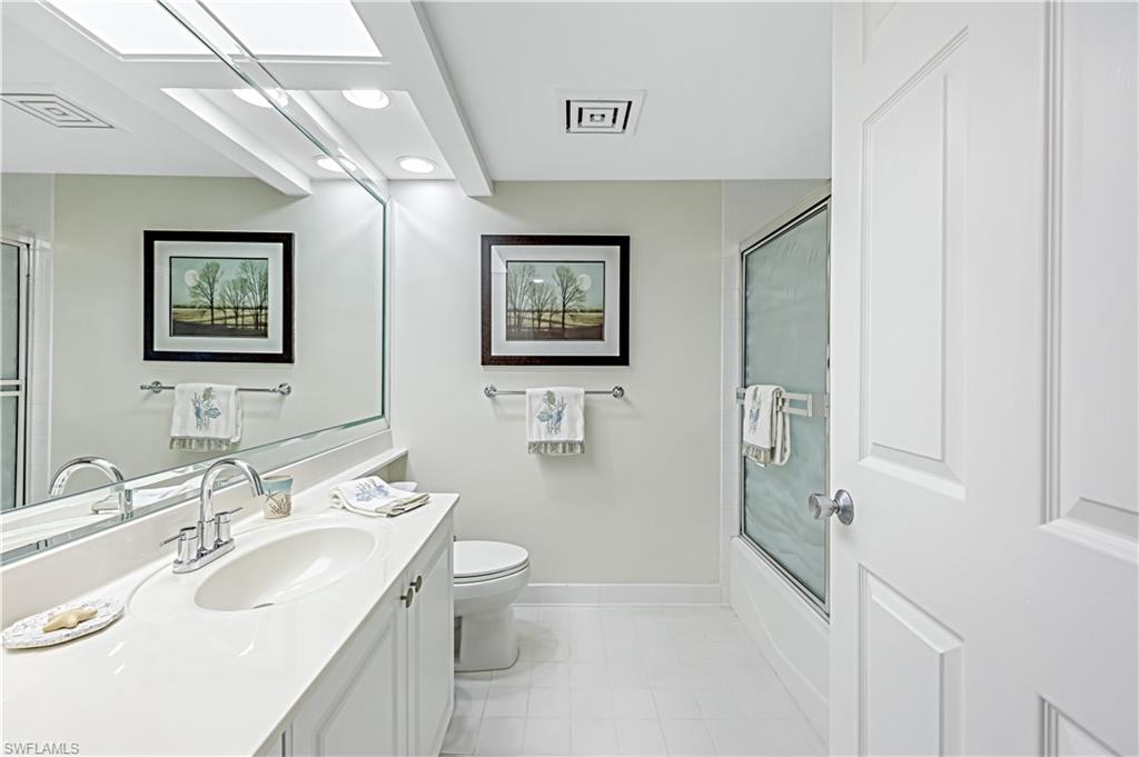 21 Bluebill Avenue, Unit B503 Naples, FL 34108 - Photo 26 of 40 a bathroom with a toilet a sink and mirror