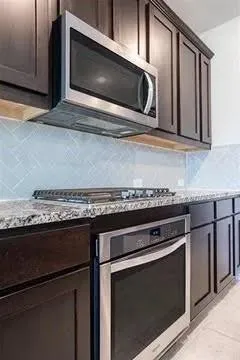 a kitchen with stainless steel appliances granite countertop a stove a sink and a microwave