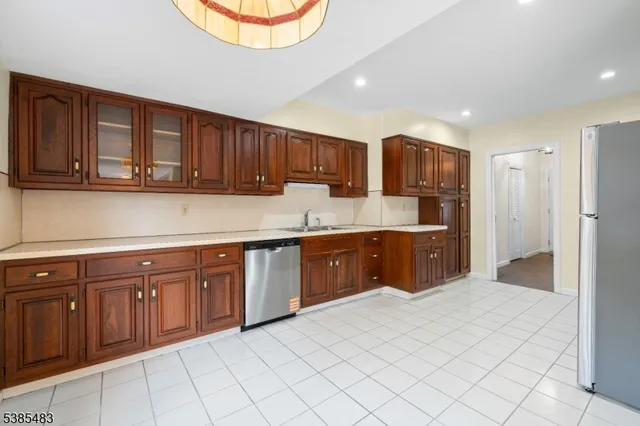a kitchen with stainless steel appliances granite countertop a refrigerator and a sink