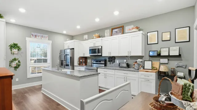 a kitchen with cabinets and wooden floor