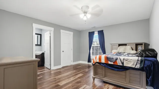 a bedroom with a bed and wooden floor