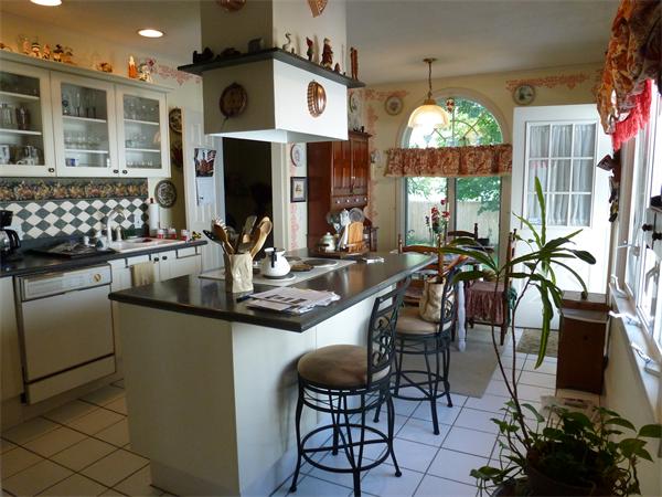 111 Larkspur Street Springfield, MA 01108 - Photo 2 of 9 a kitchen with stainless steel appliances kitchen island granite countertop a stove a refrigerator and a dining table with wooden floor