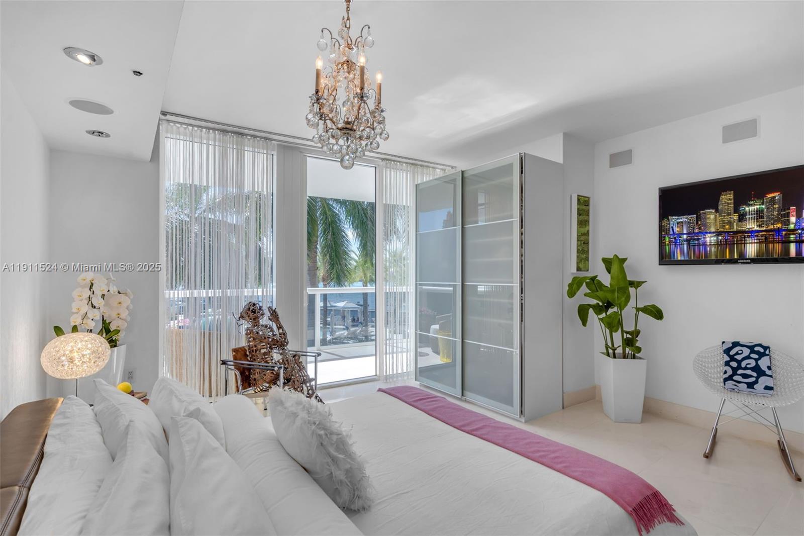 400 Alton Road, Unit 706 Miami Beach, FL 33139 - Photo 15 of 38 a bedroom with a bed and a chandelier