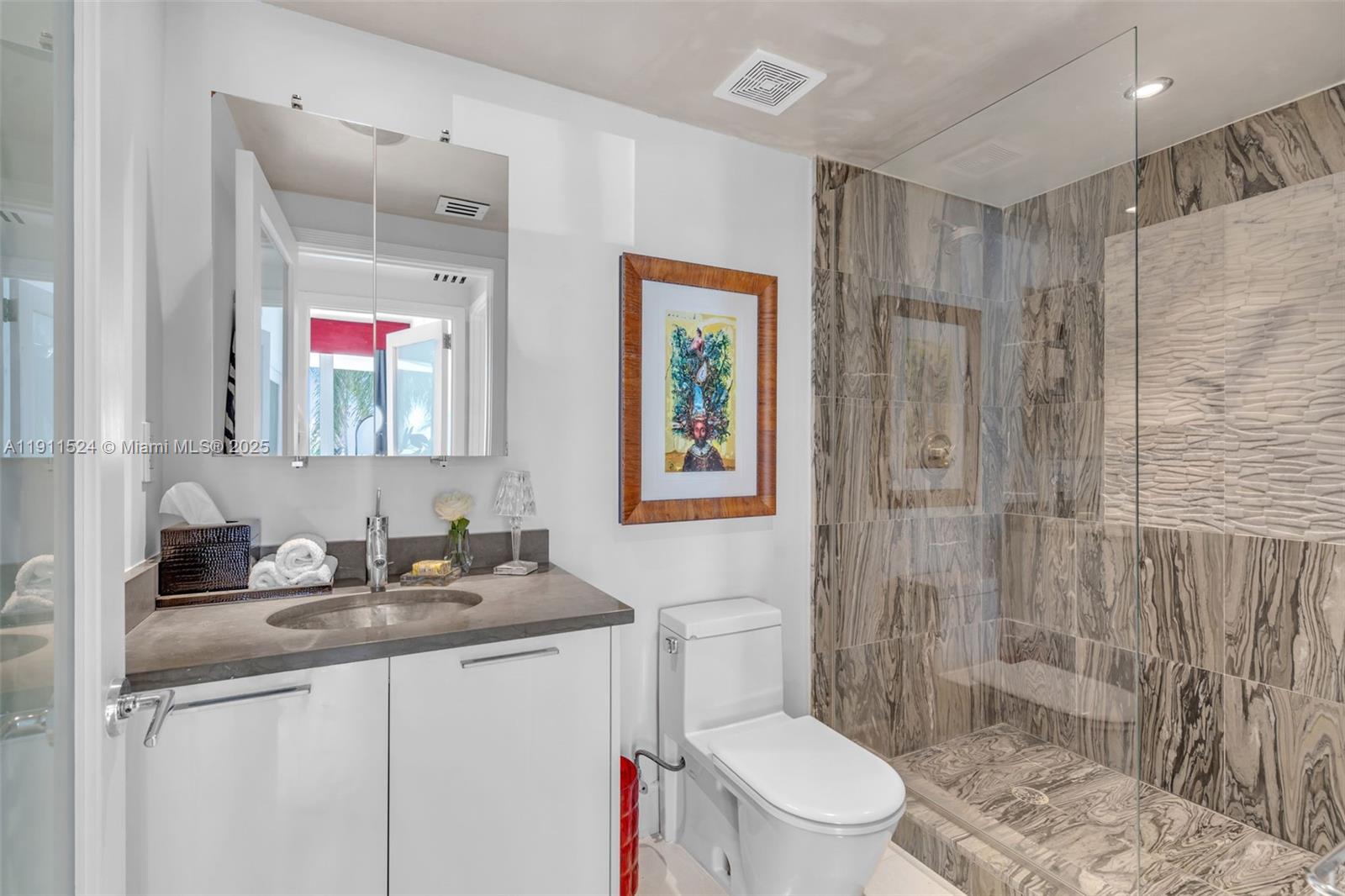 400 Alton Road, Unit 706 Miami Beach, FL 33139 - Photo 25 of 38 a bathroom with a granite countertop sink toilet and shower