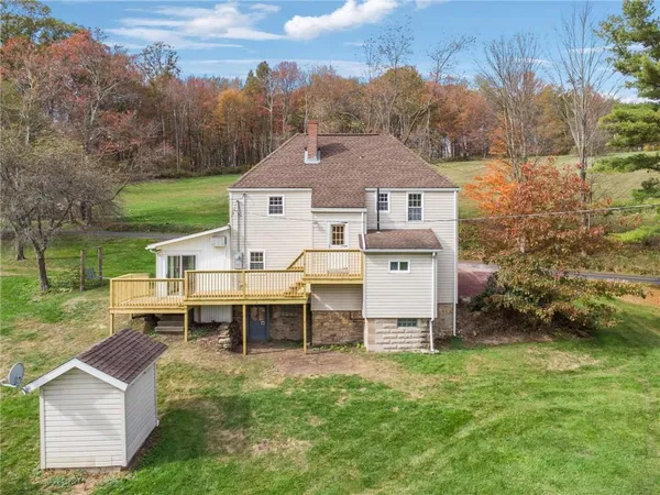 a view of a house with backyard and a tree
