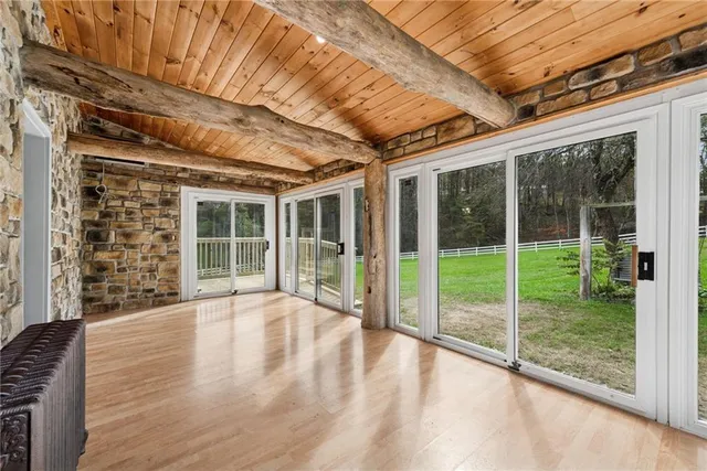 a view of a hallway with wooden floor and closet area