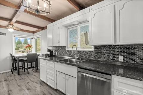 a kitchen with stainless steel appliances granite countertop a sink and cabinets