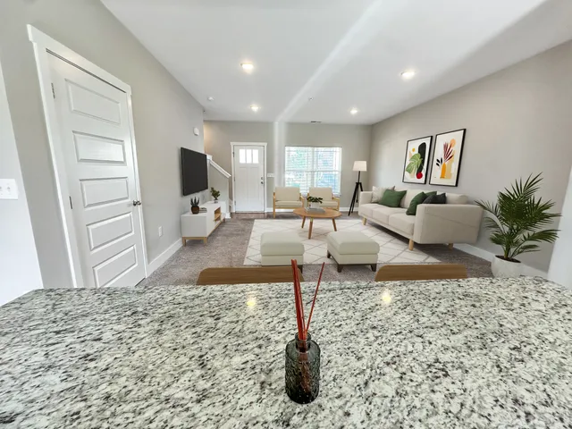 a living room with furniture and a wooden floor