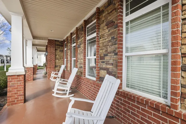 a view of a patio with couches chairs and wooden floor