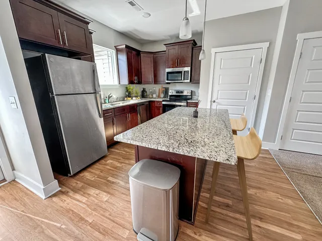a kitchen with stainless steel appliances granite countertop a refrigerator stove microwave and sink