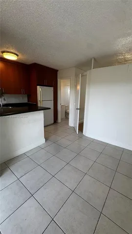 a view of a kitchen with a sink and a refrigerator