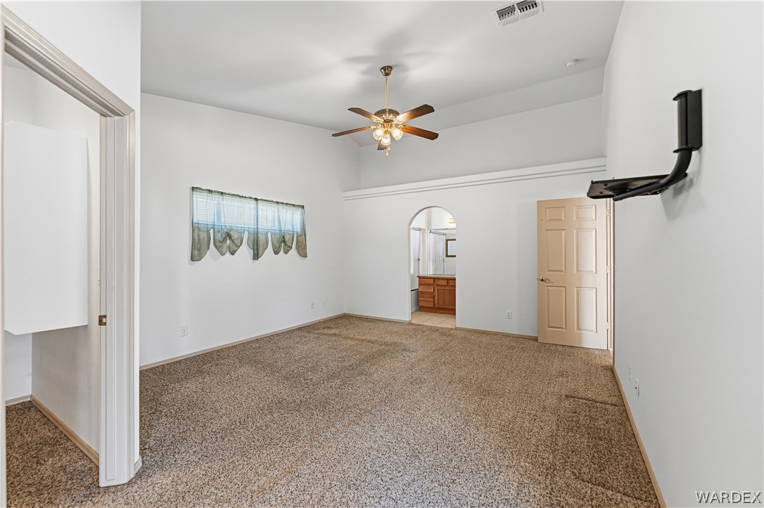 3973 Prairie View Drive Kingman, AZ 86409 - Photo 19 of 34 Spacious room with vaulted ceilings, a ceiling fan with integrated lighting, and carpeted flooring