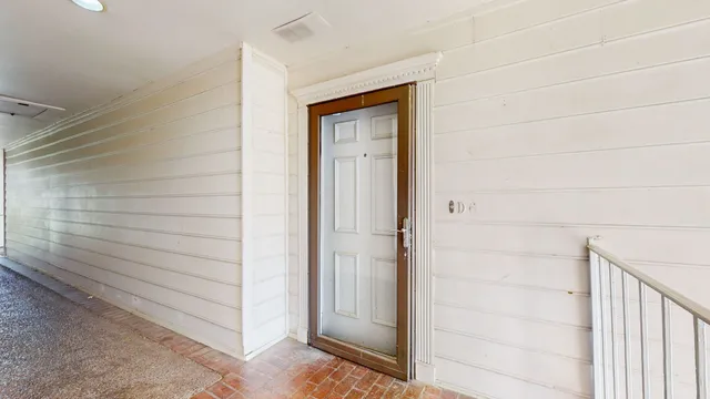 a view of a hallway with wooden floor and chandelier