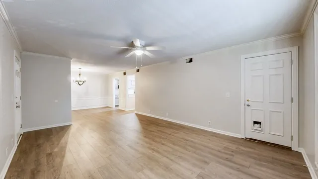 a view of an empty room with wooden floor