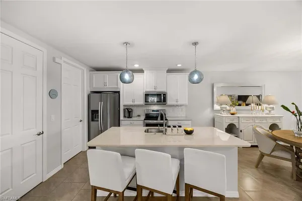 a kitchen with stainless steel appliances granite countertop a sink a stove and a refrigerator