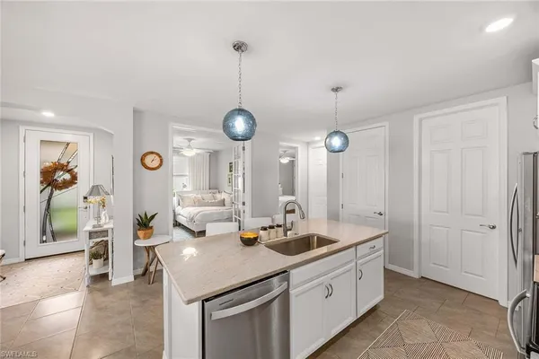 a large kitchen with kitchen island a large counter space a sink stainless steel appliances and cabinets