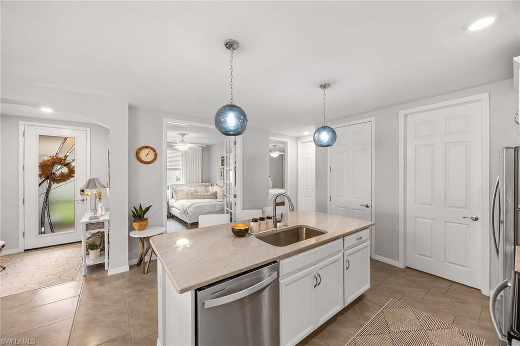 14610 Edgewater Circle Naples, FL 34114 - Photo 15 of 38 a kitchen with stainless steel appliances kitchen island granite countertop a sink a stove and a wooden floors