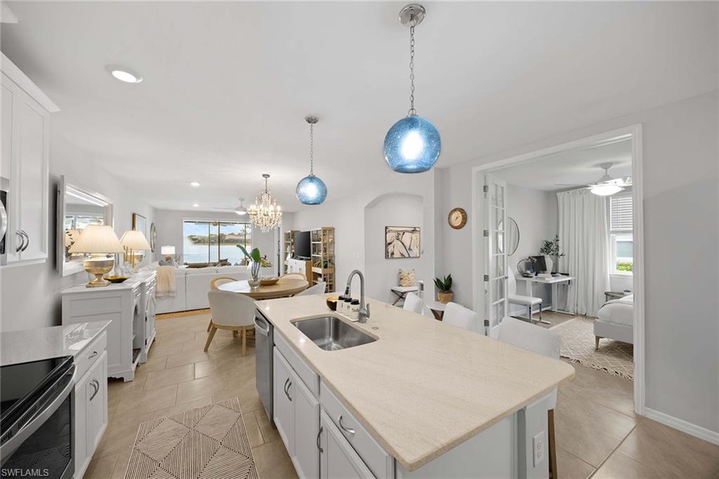 14610 Edgewater Circle Naples, FL 34114 - Photo 16 of 38 a large kitchen with kitchen island a large counter space a sink stainless steel appliances and cabinets