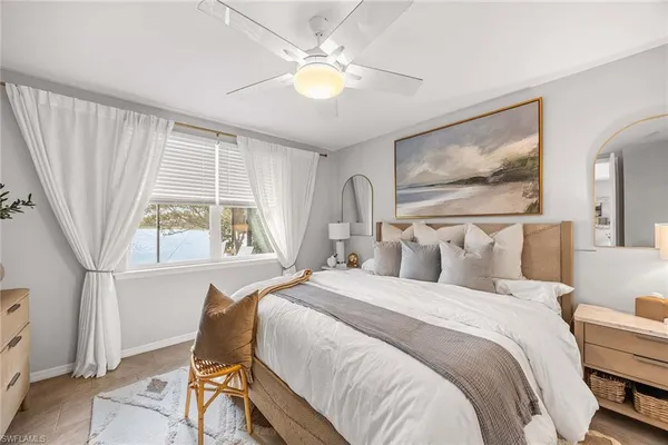 a bedroom with a large bed and a flat tv screen on dresser