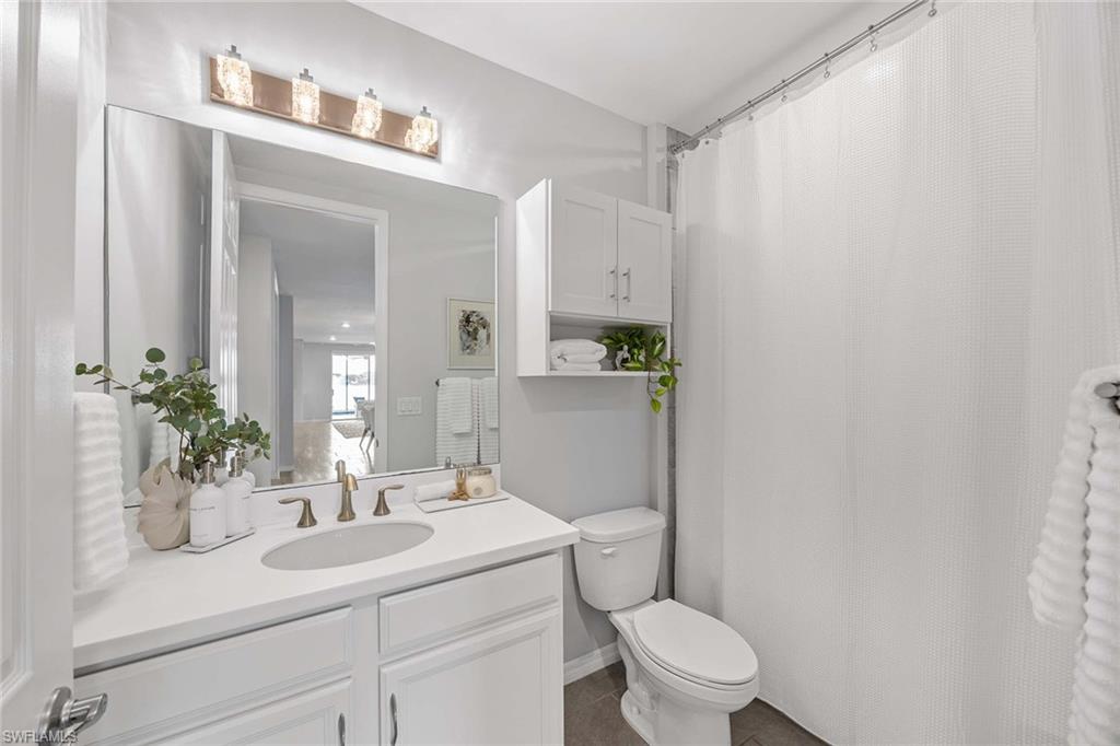 14610 Edgewater Circle Naples, FL 34114 - Photo 23 of 38 a bathroom with a sink a toilet and a mirror