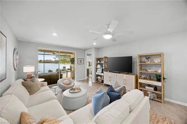 a living room with lots of white furniture and couches