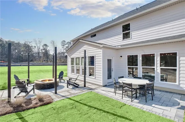 a view of a house with backyard and sitting area