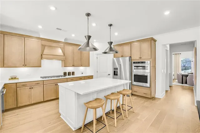 a kitchen with stainless steel appliances kitchen island granite countertop a stove a sink and a refrigerator