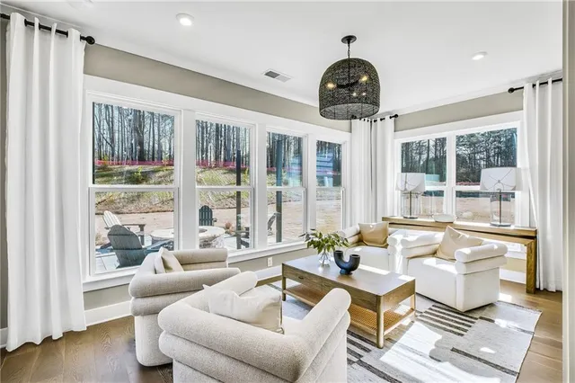a living room with furniture and floor to ceiling windows